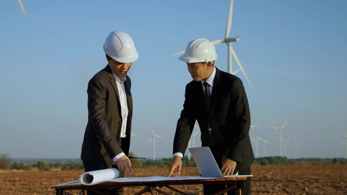 在风力涡轮机领域，商人和工程师正在就绿色清洁可再生能源风力发电项目进行咨询和集思广益.