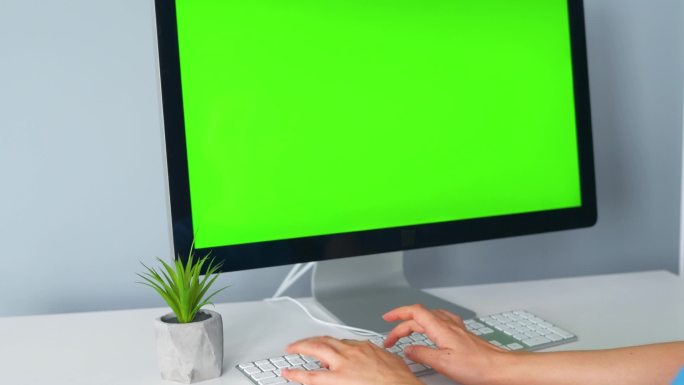女人在电脑键盘上打字，用绿色屏幕进行监控。铬键。复制空间.