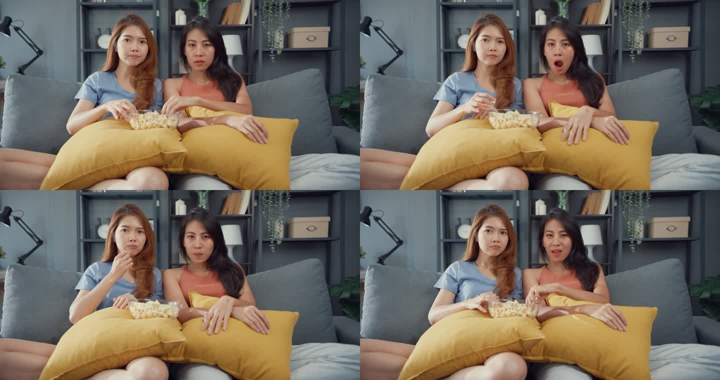 迷人的亚洲可爱的情侣女士带着轻松的快乐，在家里客厅的沙发上欣赏在线电影娱乐。生活方式检疫概念.