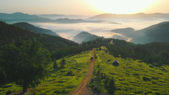 山中的晨景。在土路上飞奔，在日出时分，山谷中笼罩着美丽的雾气.