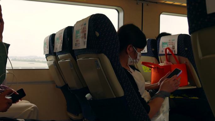 高铁列车上看手机的旅客