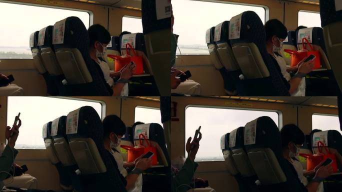 高铁列车上看手机的旅客