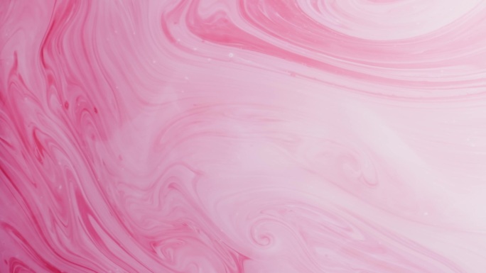 五颜六色的粉红和白色的油漆线和水滴混合在一起。墨水在旋转。水下作业