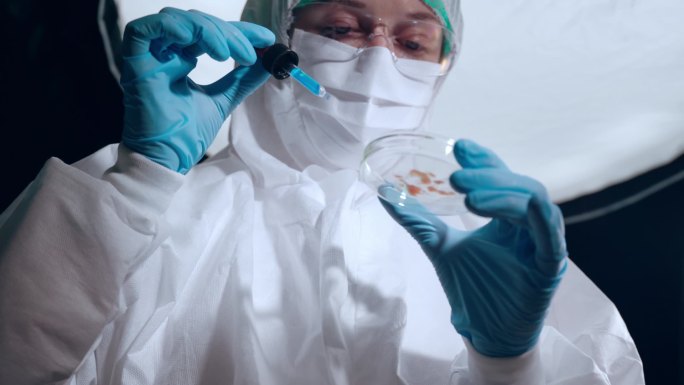 在安全的高级实验室进行培养皿的科学研究，集中与细菌和组织打交道的化学家，将化学试剂从玻璃器皿上扔到盘