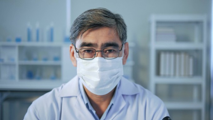 在医学实验室里戴着无菌面具看着相机的亚洲高级医生的画像。研究人员概念。近视;近视。