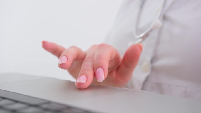 女性手触碰白色电脑键盘按钮的特写。高质量的照片