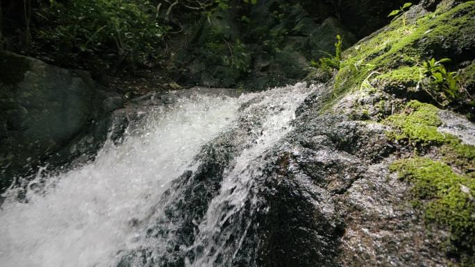 热带河流中的河流或湖泊瀑布运动缓慢，自然优美。野生山川清澈清澈的溪流.被石碑流淌的吱吱嘎吱的小溪射中