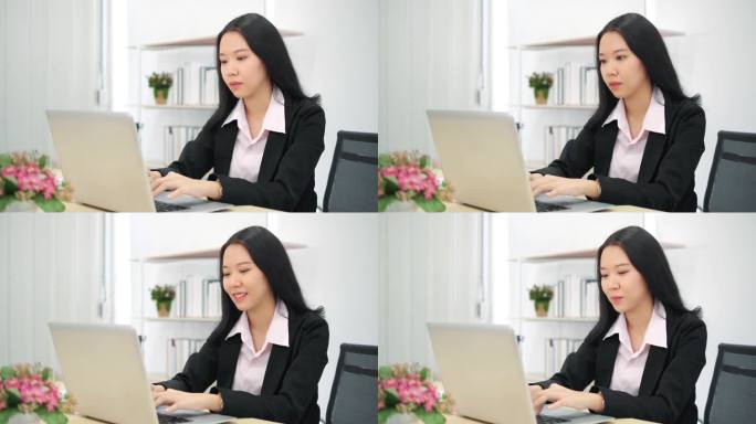 使用笔记本电脑键盘打字的亚洲女商业女性专业用户坐在写字台前，与pc应用软件技术概念一起在网上工作.