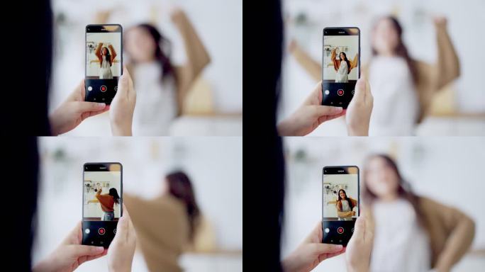 在为社交媒体制作视频时，年轻的亚洲女人一起在厨房里跳着舞，家里流行的舞蹈在网上制作内容
