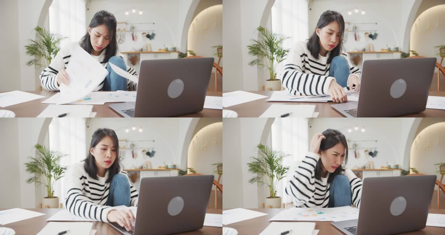 年轻的亚洲女性自由撰稿人专注于笔记本电脑的演示工作，以及在家里厨房与公司进行远程会议的财务项目。女生
