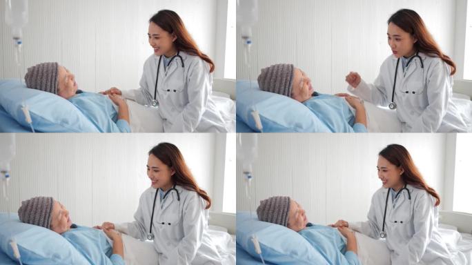 有爱心的亚洲医生在医院病床上看望老年妇女病人，友好的医生牵着病人的手与她交谈，感到好消息。老年人保健