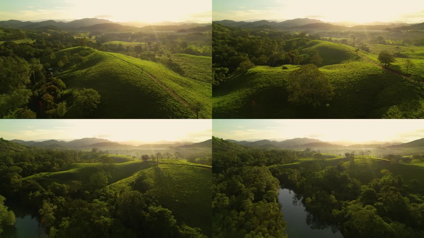 飞行员:在美丽的雾蒙蒙的早晨,在茂密的绿色热带风景上空倒飞.静谧的河水在金色的夕阳下流过青山.日出时