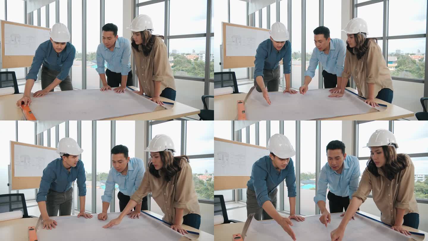 亚洲集团的设计师们在办公室的商务会议桌上制定了一个蓝图，建筑师们在讨论业务计划.