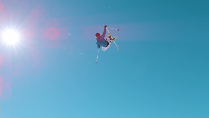 慢动作年轻的男子运动员在滑雪胜地的雪地公园里跳着大气。自由式滑雪者用抓斗做特技.雪山的极端行动.