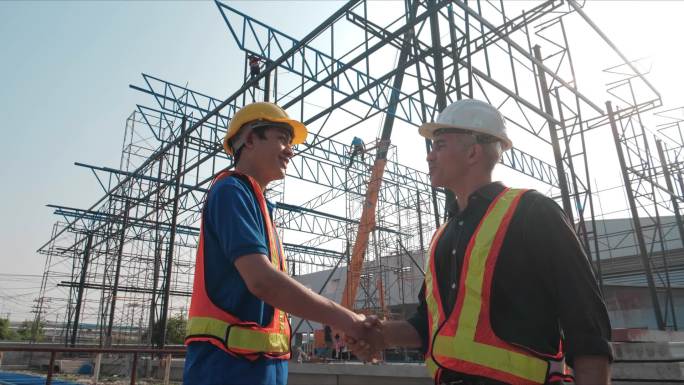 工程师在建筑工地与亚洲企业握手.员工或员工与雇主握手问候、交易、团队合作、合作等