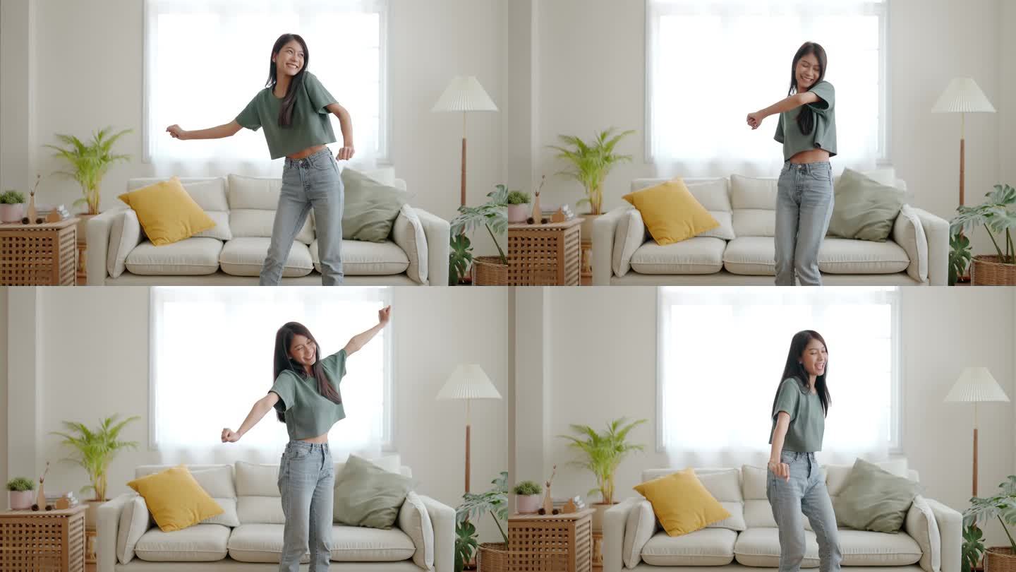 年轻的亚洲女人在家里客厅的地板上跳舞。快乐的亚洲女人笑着在家里放松，健康的精神健康和幸福