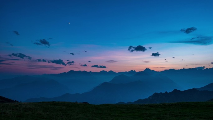 一天晚上相隔时间从上阿尔卑斯山的高处。七彩的晚霞，山峰和雾中下面的山谷，云彩，设置月亮和自转的恒星.
