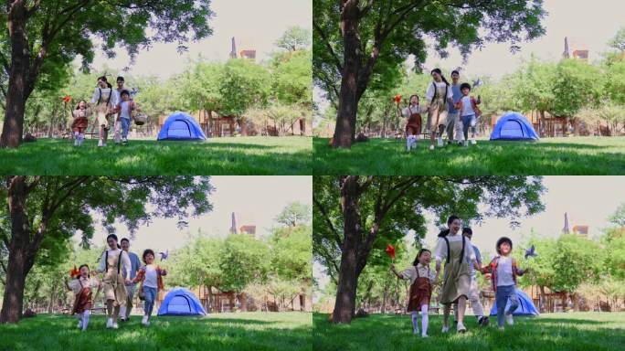 一家四口露营在草地上开心散步