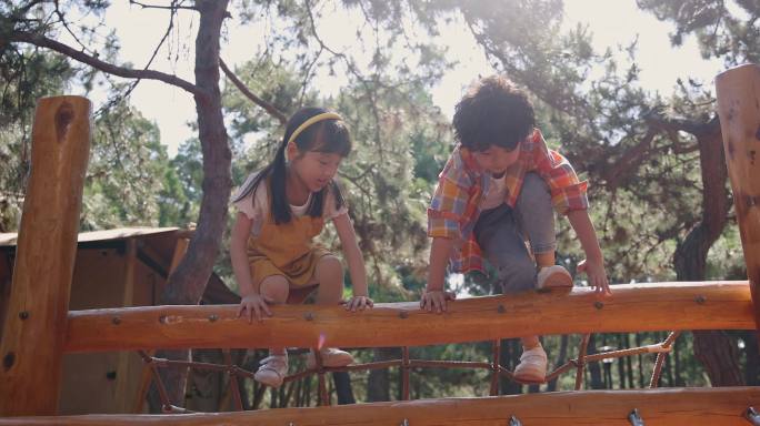 两个小孩子开心玩攀爬架