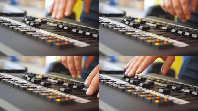 男性音响工程师的手按下键和移动按钮的板。工作在专业数字音频频道调音台的人的胳膊。放大器和声音平衡。关
