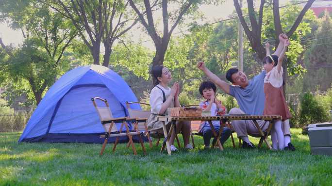 一家四口在露营地玩游戏开心欢呼庆祝