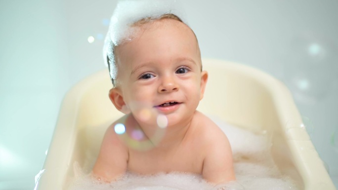 快乐宝贝男孩洗澡用肥皂泡沫的慢动作镜头