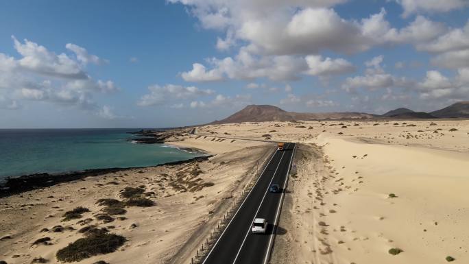 无人机航拍汽车行驶在海边沙滩公路上天际线