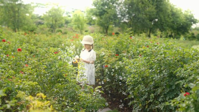 小女孩在玫瑰花园吹泡泡