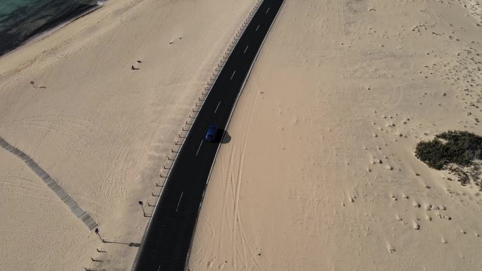 无人机航拍汽车行驶在海边沙滩公路上天际线