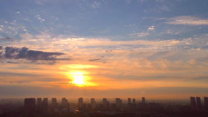 日出东方朝霞城市天际线太阳穿过云层