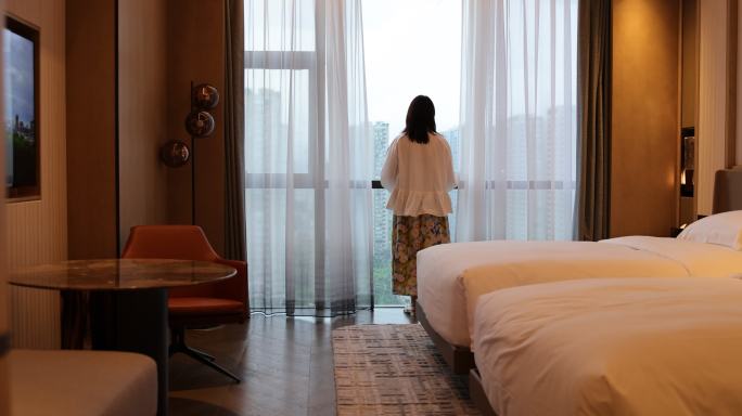 在酒店度假的女人 拉开自动窗帘