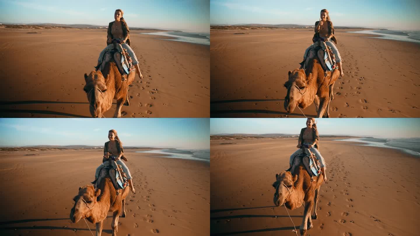 在沙滩上骑骆驼的女游客竖起大拇指