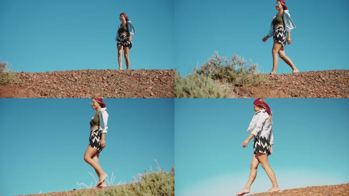 夏天，在晴朗的天空下，戴着太阳镜的女人赤脚走在悬崖上