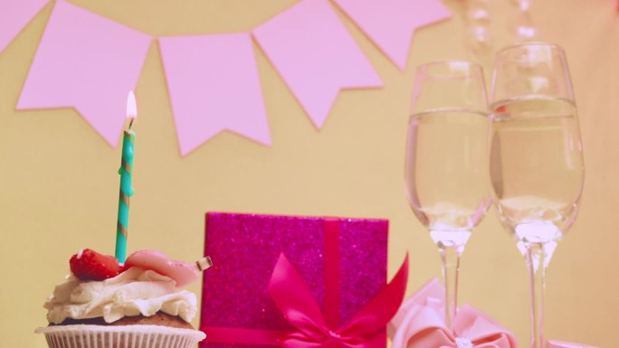 女孩的出生日期。蛋糕和燃烧的蜡烛。用香槟祝贺。粉红色的蝴蝶结和礼盒。周年纪念日。给女人的视频明信片
