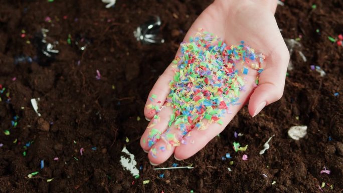 微塑料污染地球，塑料颗粒在土壤中的特写，持有垃圾和垃圾，环境生态问题。全球变暖和气候变化。