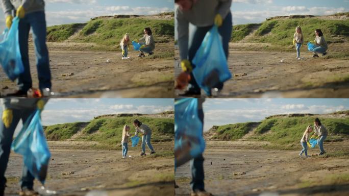 一家人清理河滩上的塑料垃圾，小女孩和她的妈妈把垃圾装进袋子里
