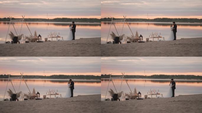 在美丽的日落湖边亲吻新婚夫妇，全裸拍摄，爱与幸福