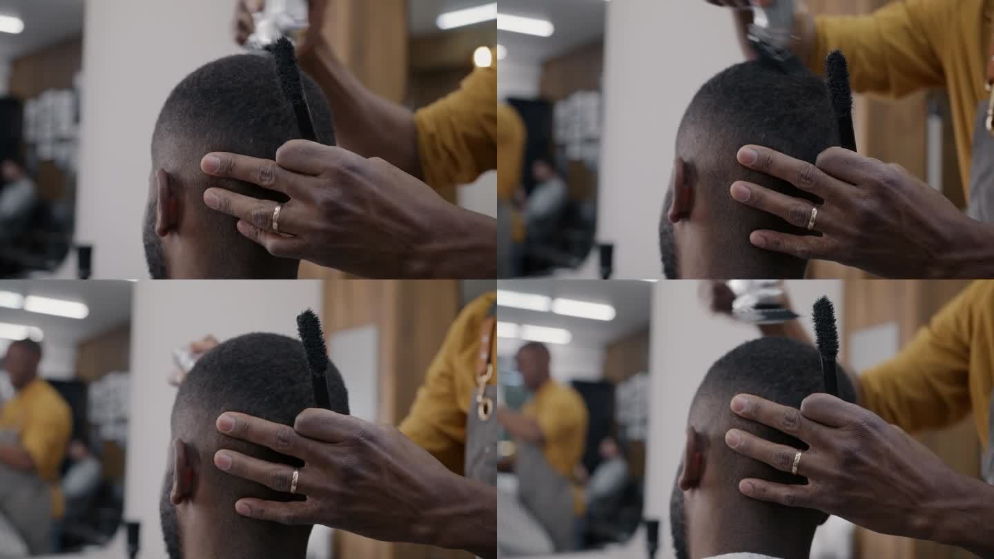 理发店员工在工作室里用机器给客户剃发的特写