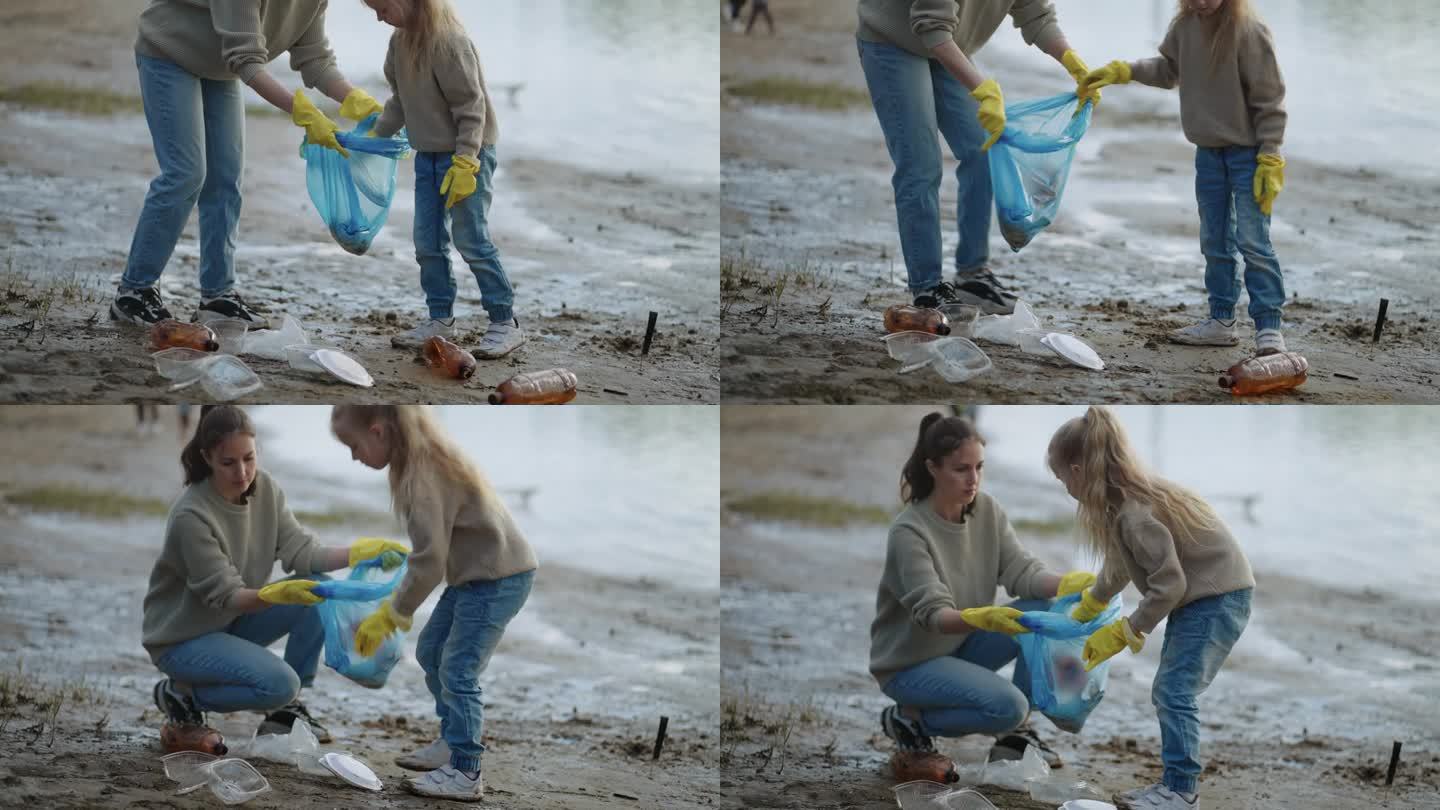 母亲和小女孩志愿者收集海岸垃圾，生态和环境保护