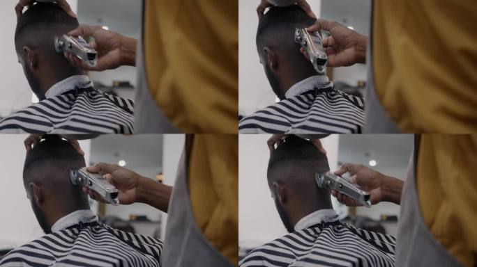 在沙龙里，熟练的理发师使用剃须机给非裔美国人理发的特写