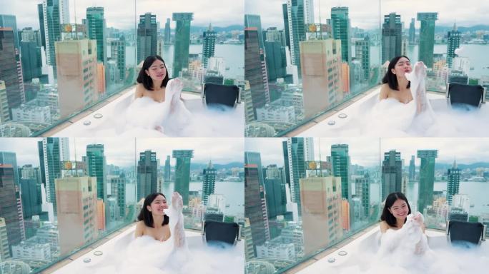 来香港旅游的女孩和私人屋顶房间的按摩浴缸。香港的高楼大厦。