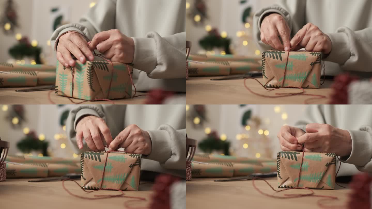 近距离用手工包装纸包裹圣诞礼物，用红绳系上蝴蝶结，用鲜花装饰。为新年节日准备礼物