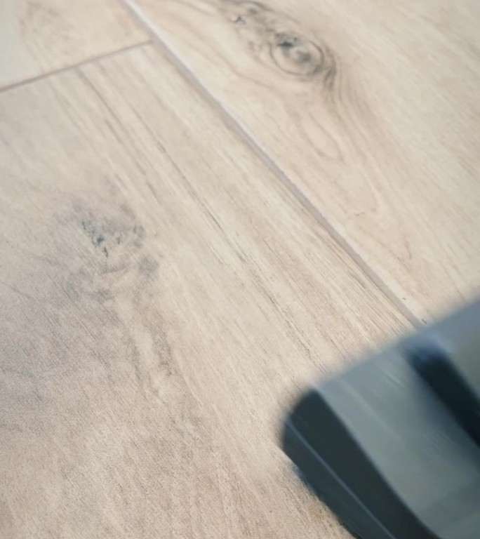 女服务员用真空吸尘器清洁公寓地板。垂直视频