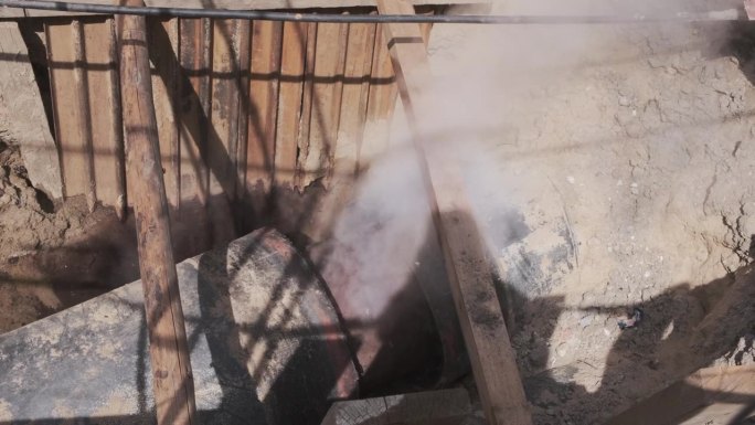 热蒸汽从地下管道中冒出。埋地用于固定地下热水供应管道。建筑工地管道里沸腾的水。