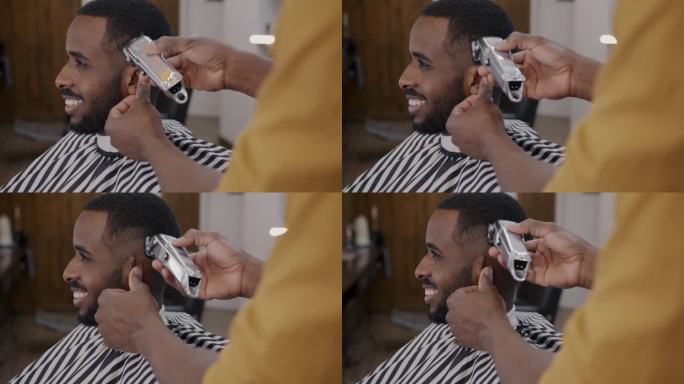 理发师在理发店用剃须机剃毛时，一个非洲裔美国人微笑的侧视图