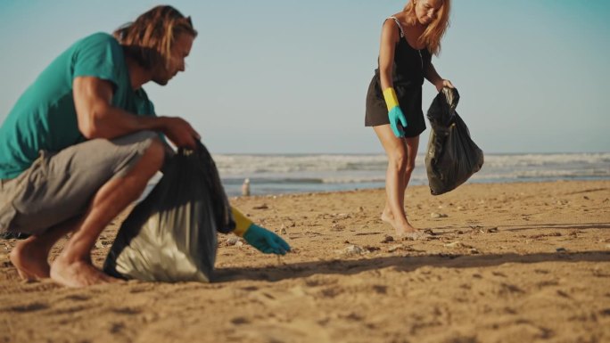 一男一女在海滩捡垃圾