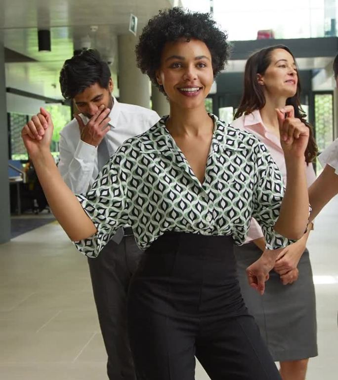 多元文化商业团队在办公室大堂欢笑起舞的垂直视频