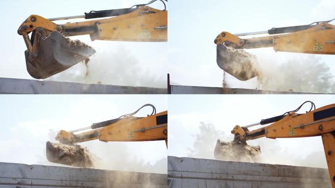 工业挖掘机在公路施工现场将土料装入自卸车，慢动作