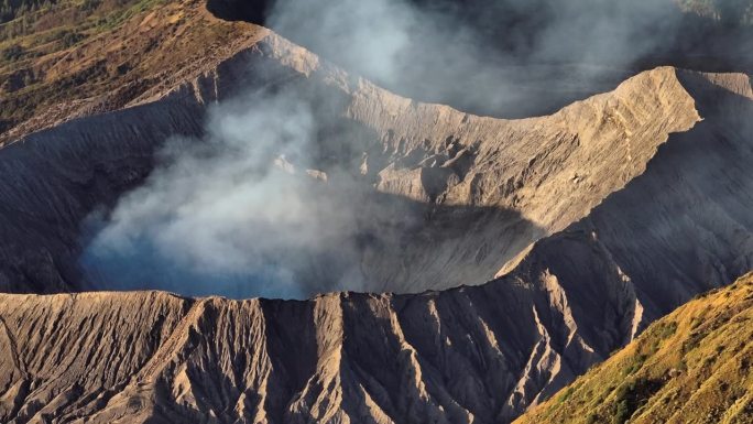 航拍无人机拍摄的日出场景，火山喷发的烟雾被云雾包围。Bromo, sememeru, Batok和W