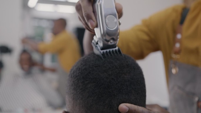 熟练的理发店专家在工作室与客户一起剃头的特写